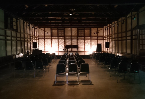 Multipurpose hall inside the old storehouse, set up with chairs for events.
