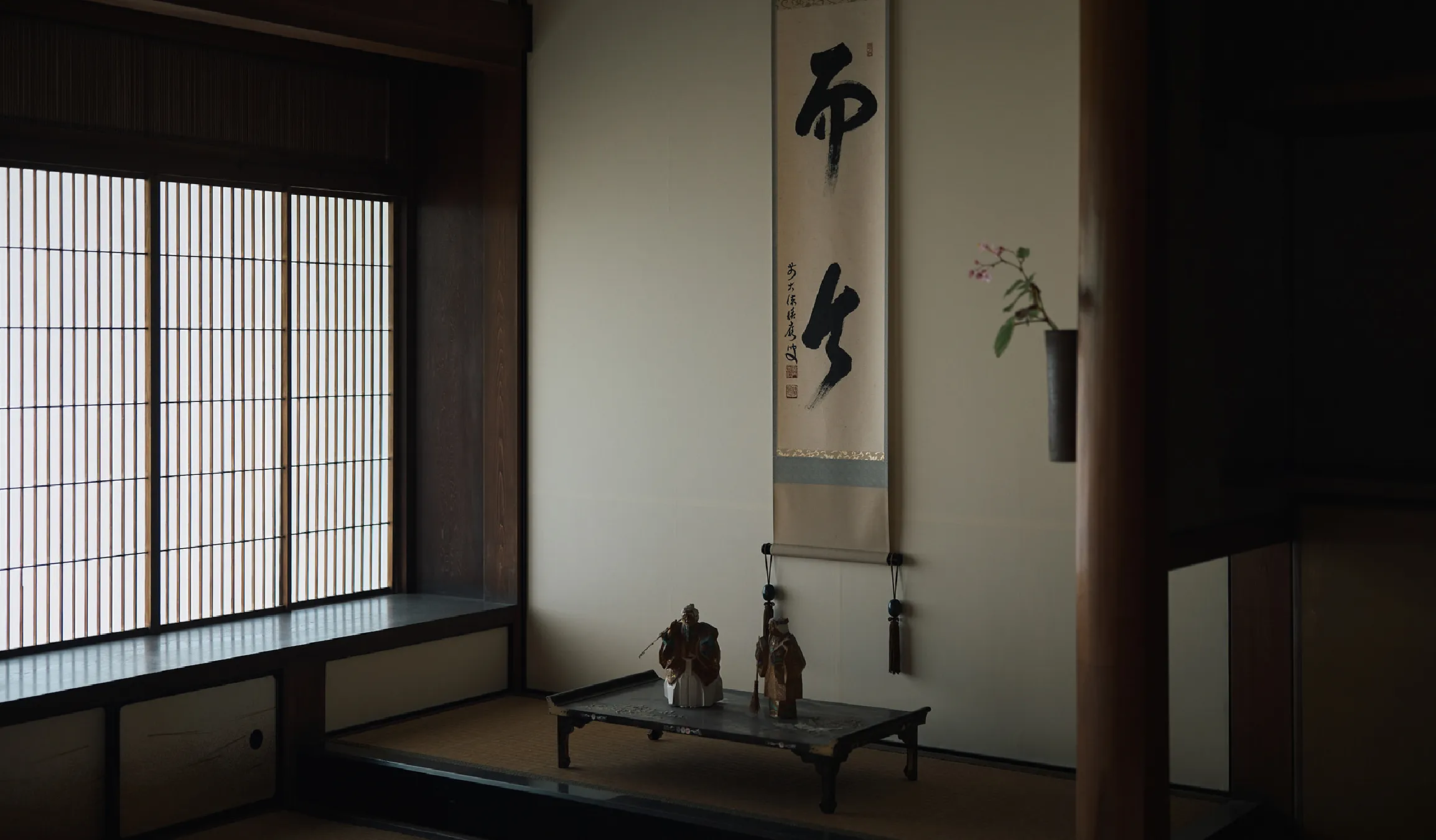 A tea room inside the historic Kiyasho Shuzo building with a hanging calligraphy scroll reading Jikon.