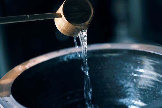 Water being ladled into a brewing vessel.