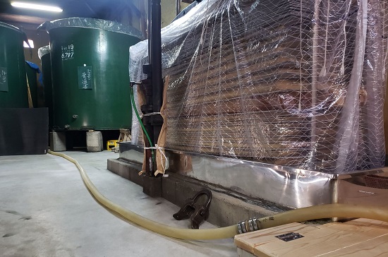 Yabuta-style sake press (moromi pressing machine) wrapped and in use.