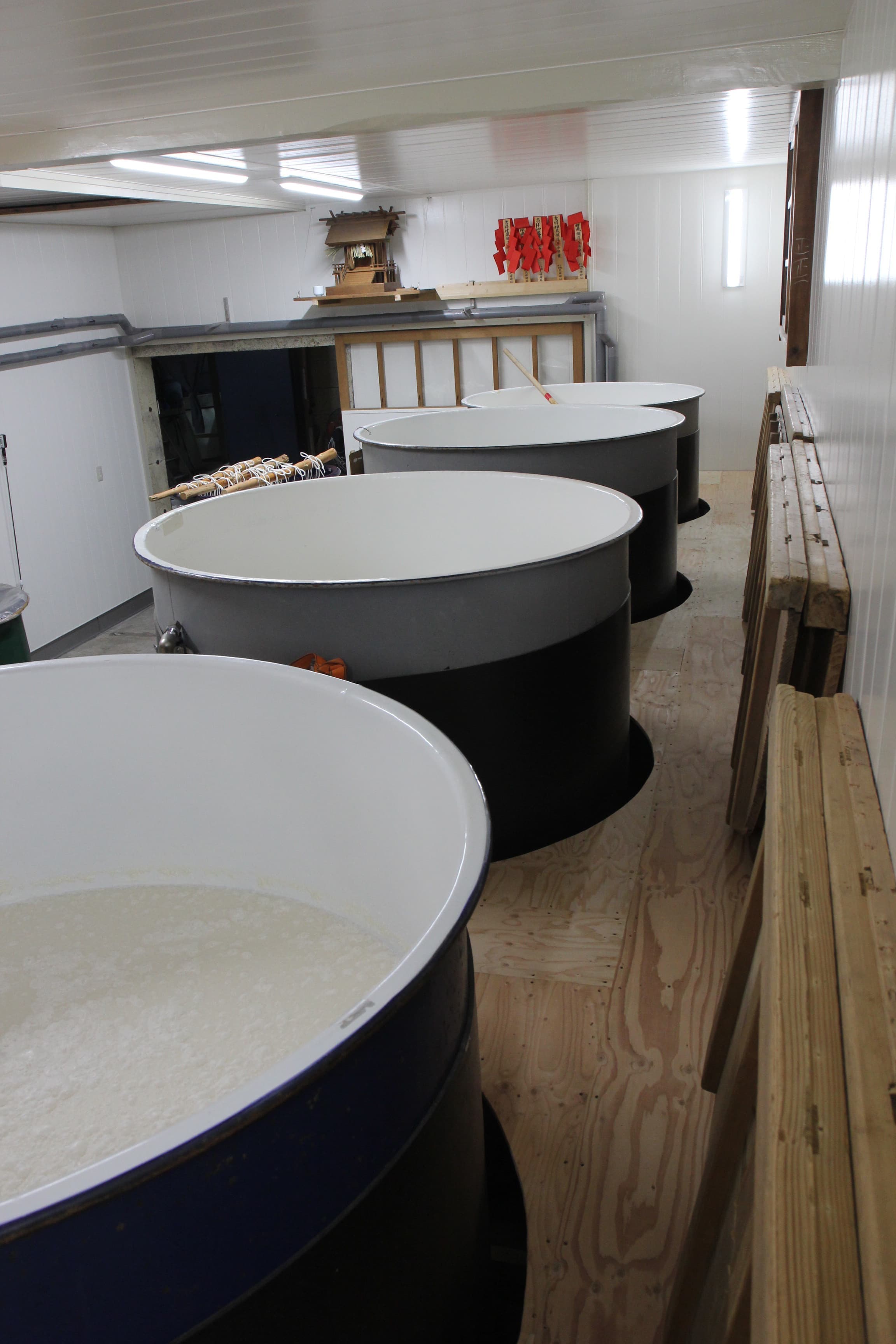 Fermentation tanks (moromi) filled with rice mash inside the brewery's kojiroom-adjacent building.