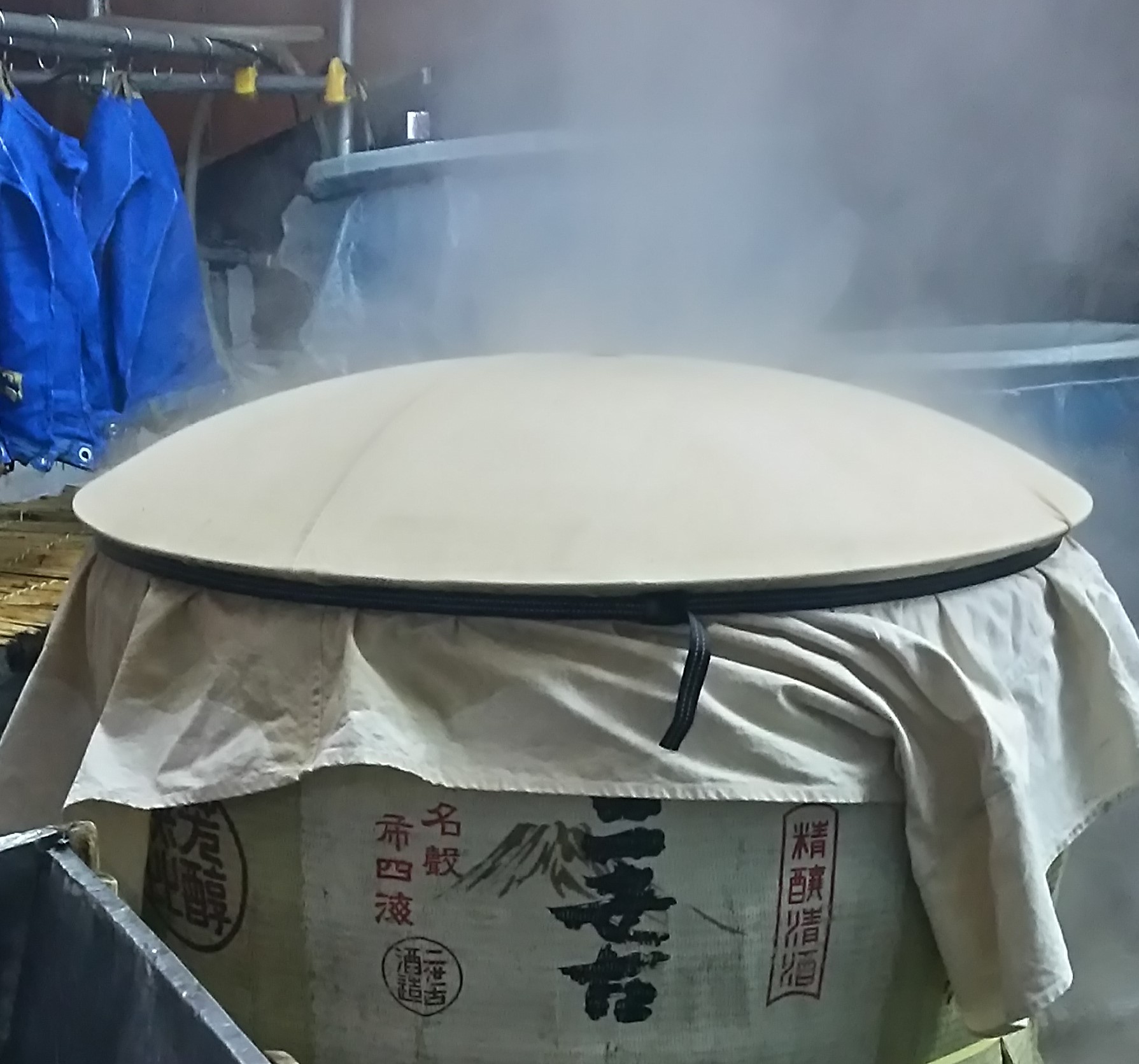Steam rising from the rice-steaming vat (kamaba) covered with cloth