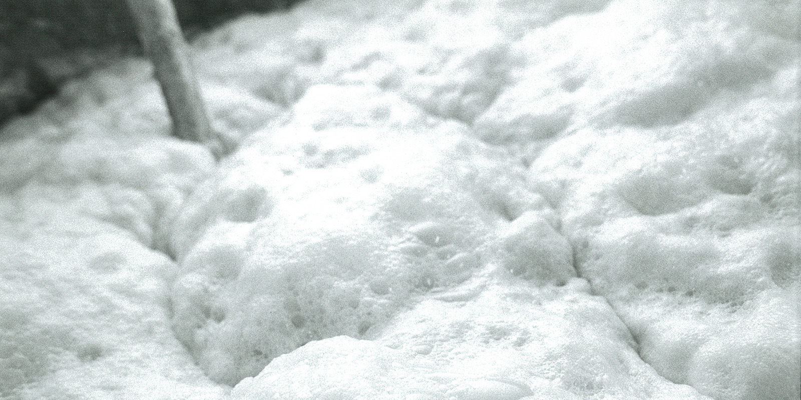 Close-up of fermenting moromi mash bubbling in the brewing tank.