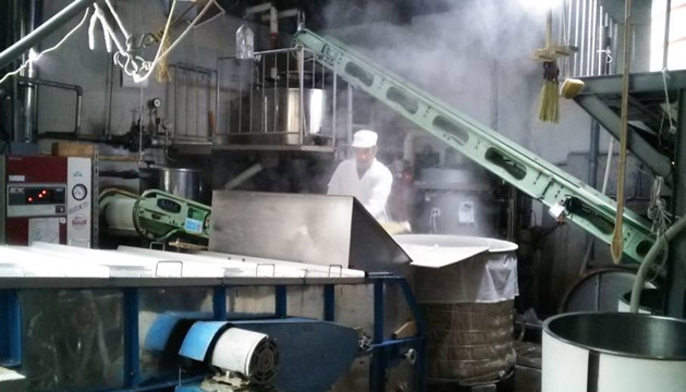 Steaming the rice in the brewery's koshiki (steaming vessel).