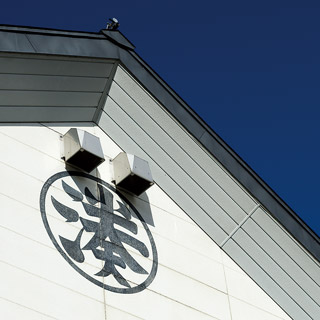 Corner of the brewery building exterior with the Shirataki emblem