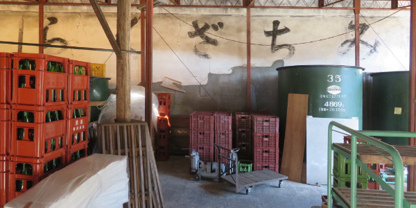 Interior storage area with brewing tanks and crates at the former Nakatsugawa brewery