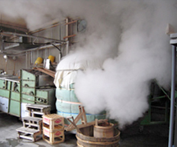 Steaming rice in the brewery's rice-steaming equipment