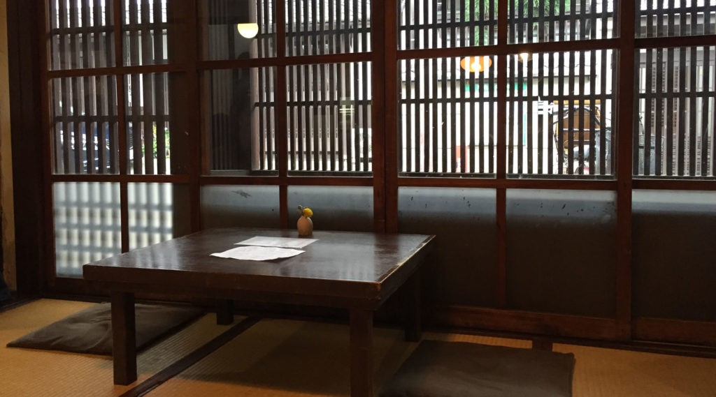 A traditional tatami room with shoji screens inside the brewery's guest space.