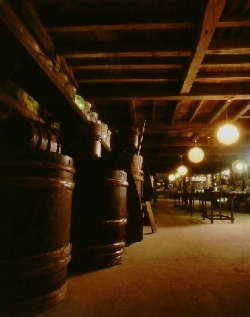 Rows of wooden sake storage barrels inside the brewery