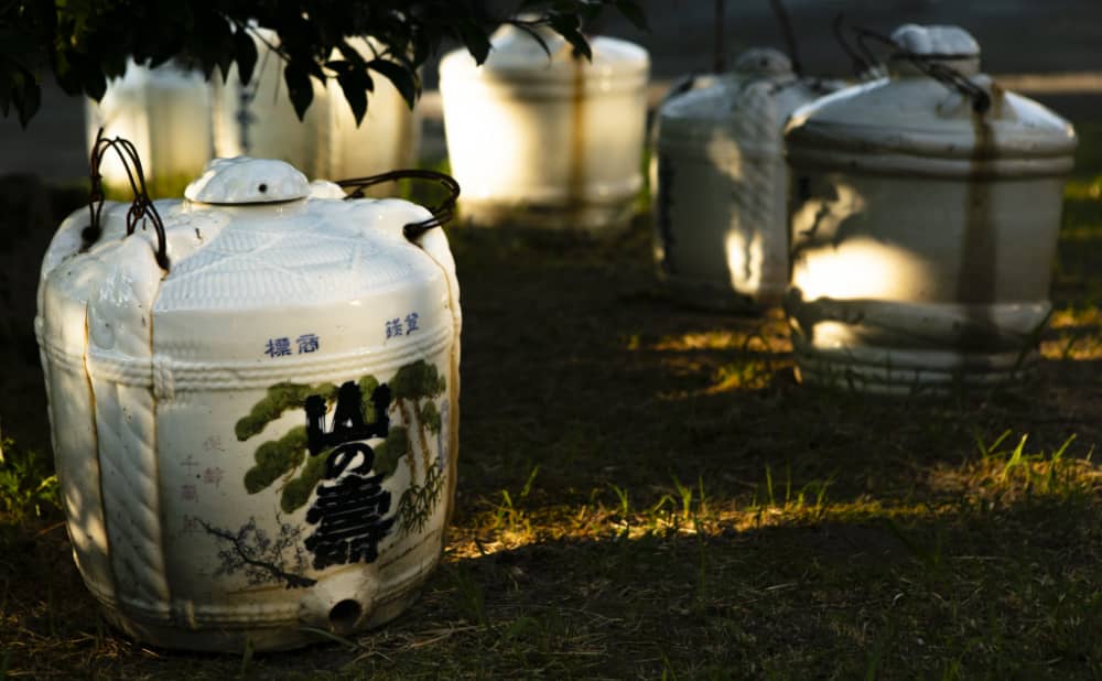 Traditional ceramic sake jars (kame) marked with the Yamanokotobuki logo