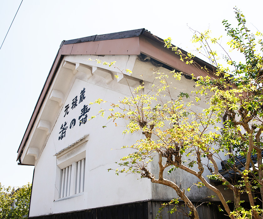 Exterior corner of the old storehouse wall bearing the inscription 'Genroku no kura'.