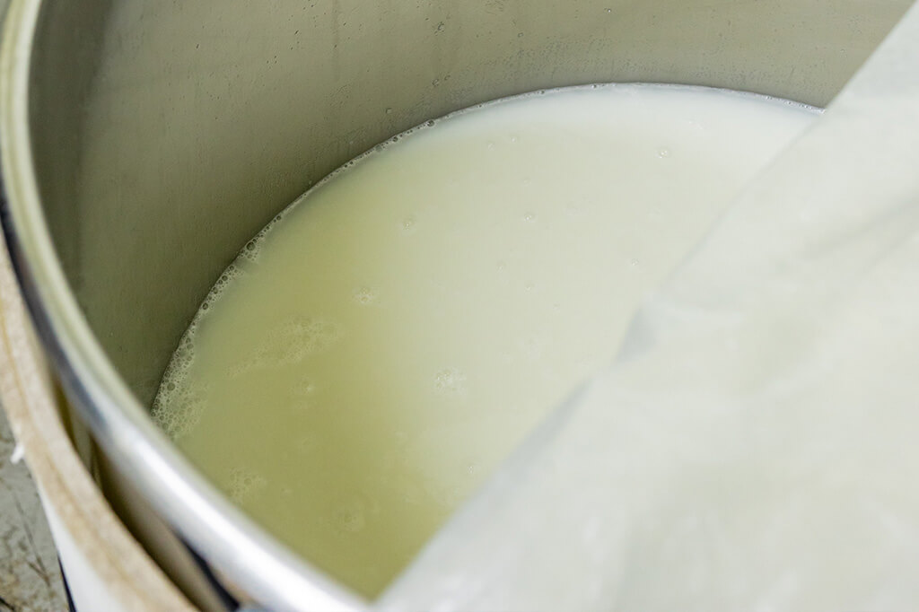 Close-up of fermenting moromi mash in a brewing tank.