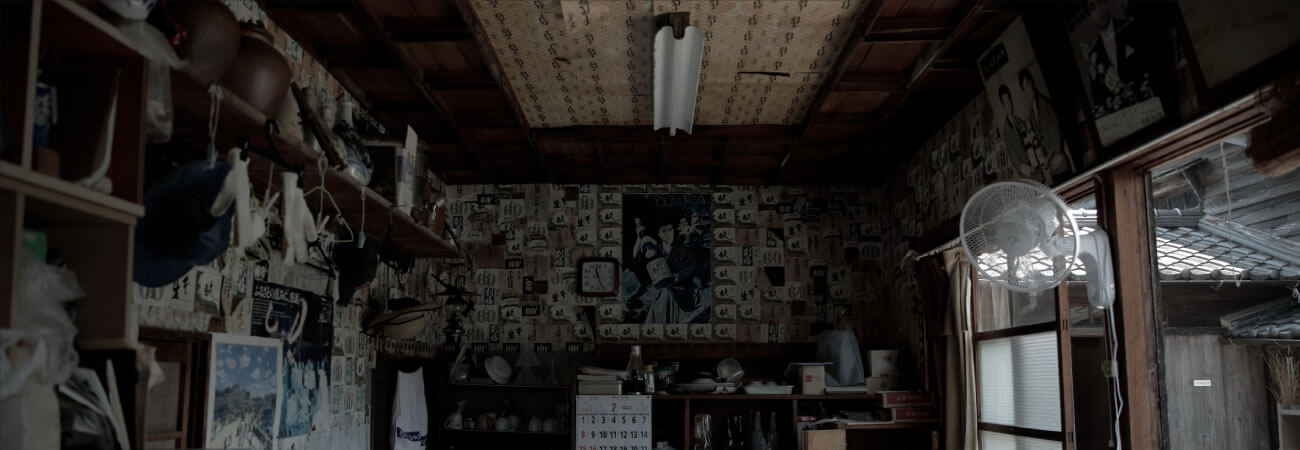 An old interior room at the brewery, walls covered with vintage sake advertisements and memorabilia.
