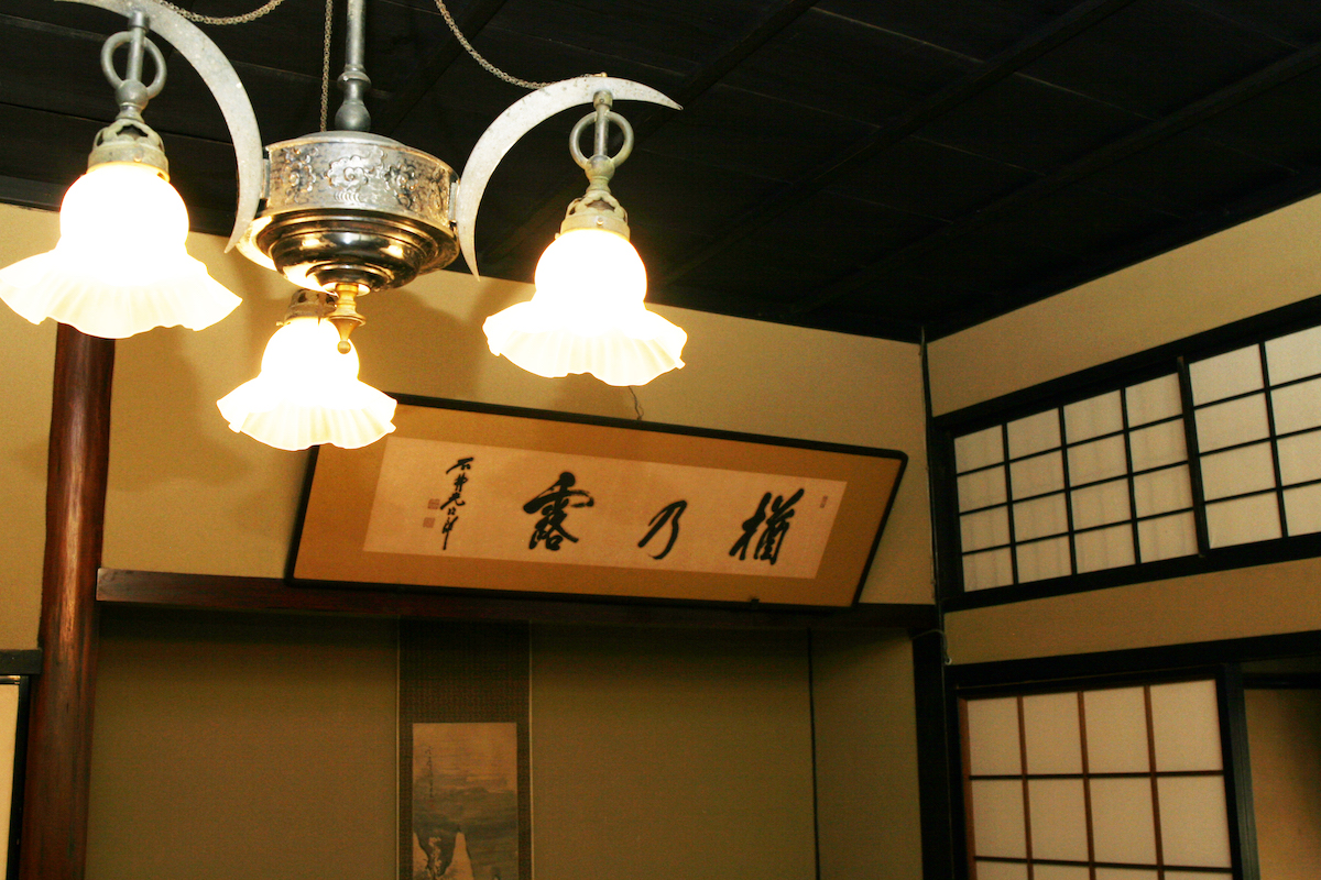 A calligraphy sign reading "Naranotsuyu" hanging in a tatami room
