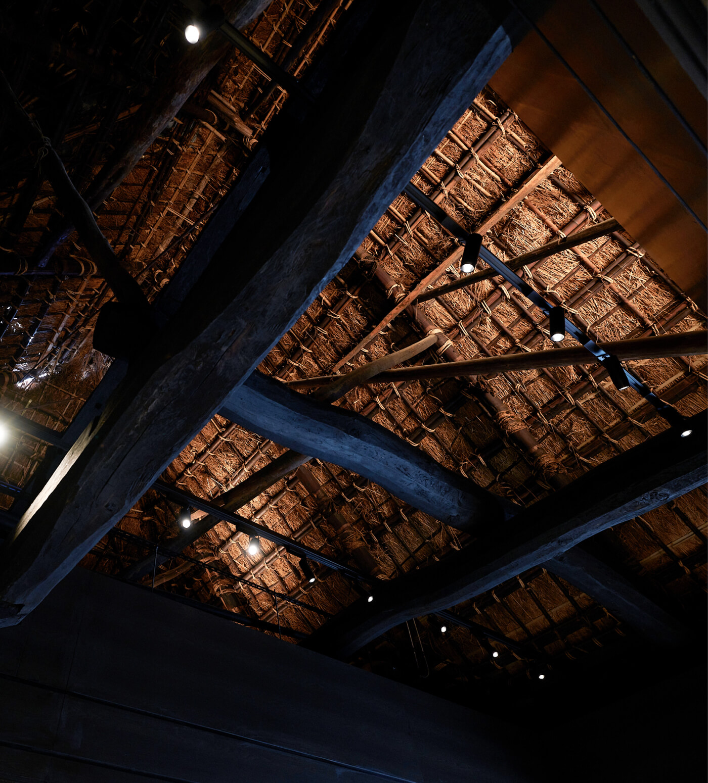 Traditional thatched roof structure and beams inside the brewery