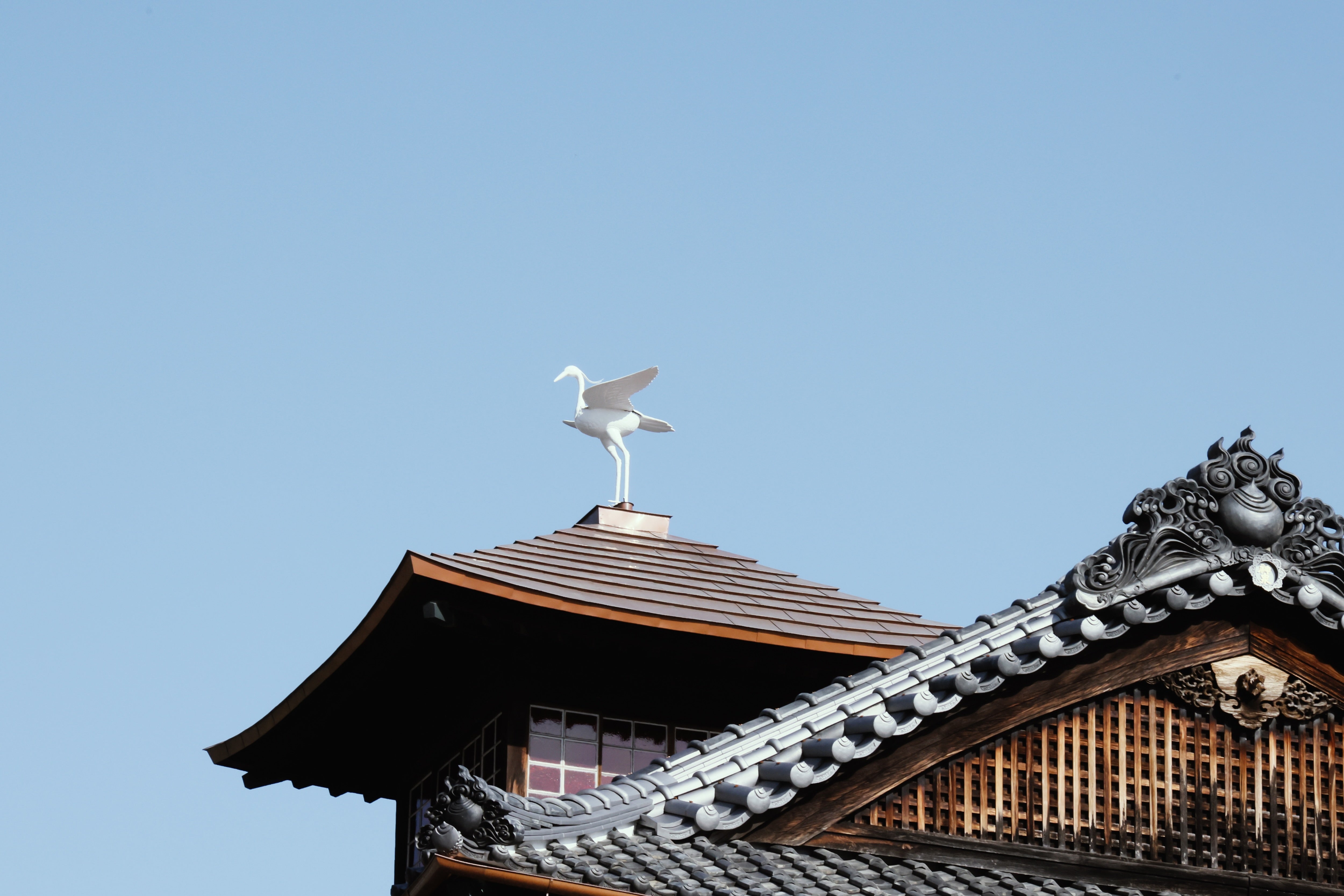 Ornamental heron figure atop the traditional tiled roof of the brewery.