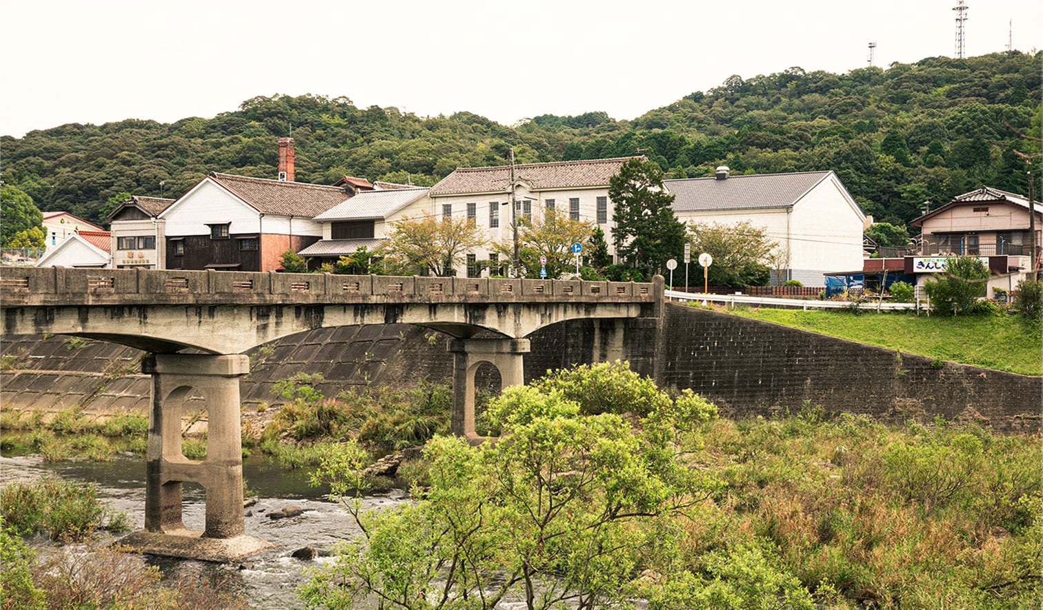Wide view of the brewery complex buildings beside the river in Ube, Yamaguchi.