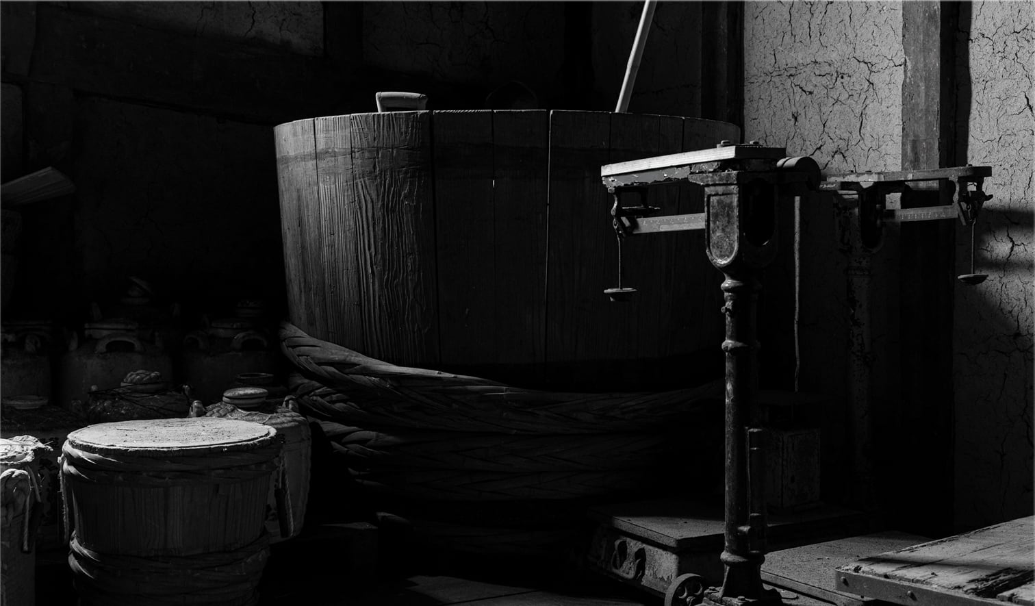 Historic interior view of a wooden fermentation vat and traditional brewing tools.