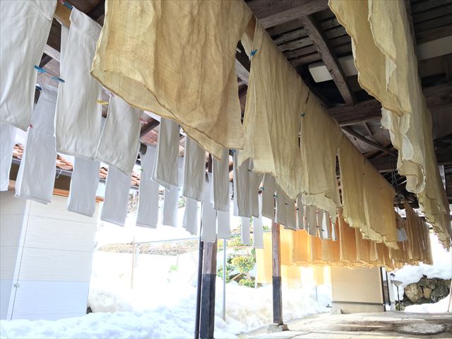 Cloth mash bags hung to drain under the eaves of the brewery building.