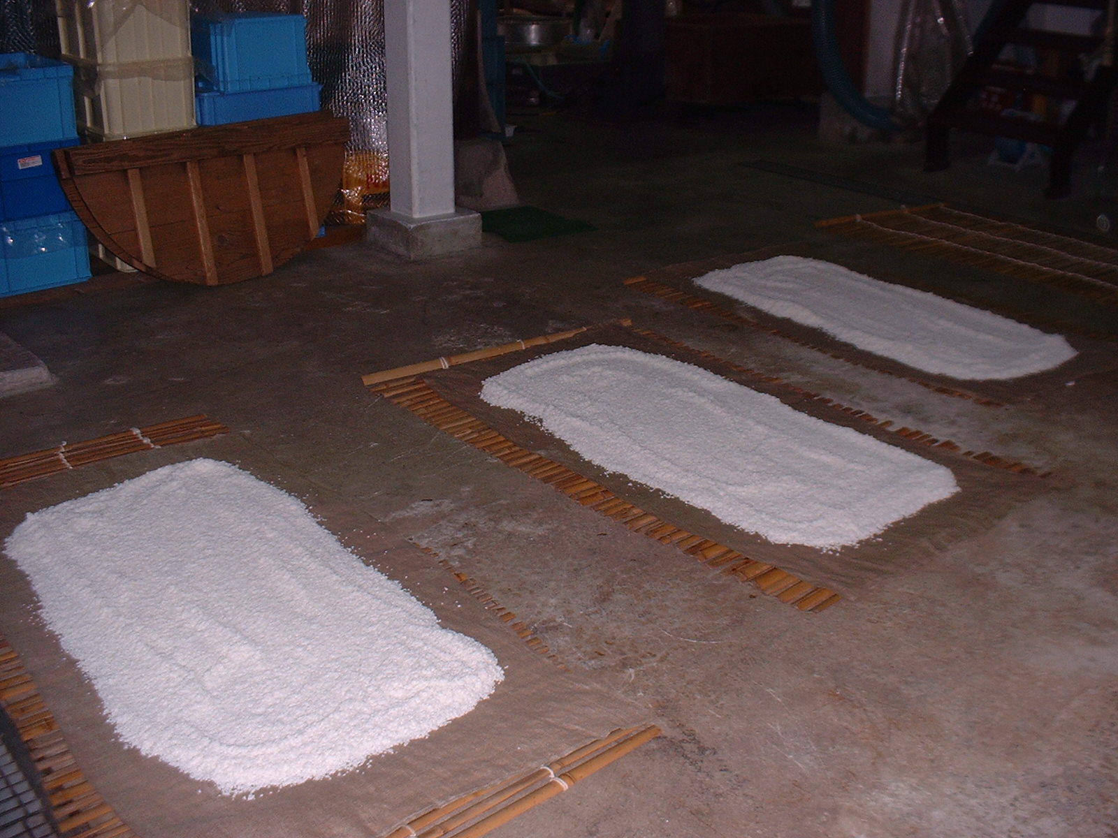 Washed rice spread out on bamboo mats to drain