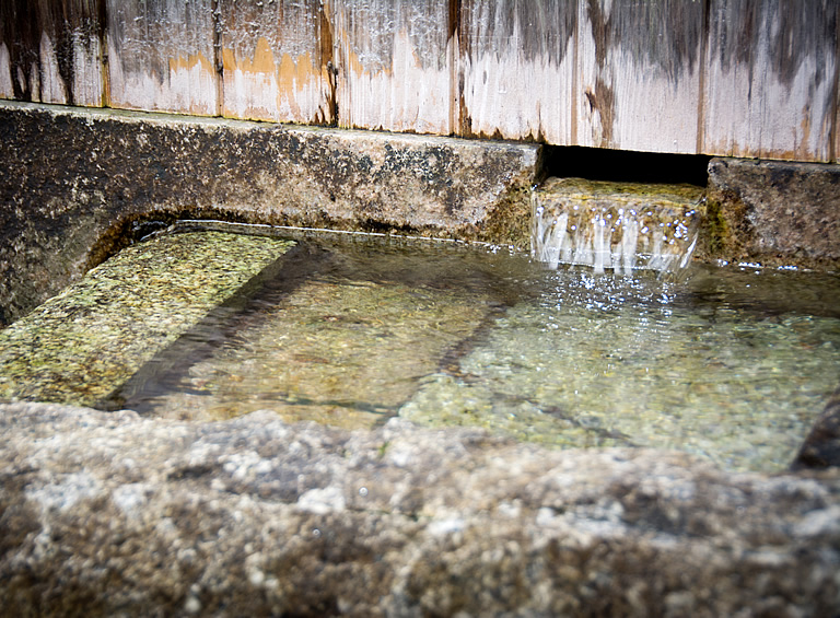 Underground water from the Suzuka mountain range flowing into a stone basin, used for brewing.