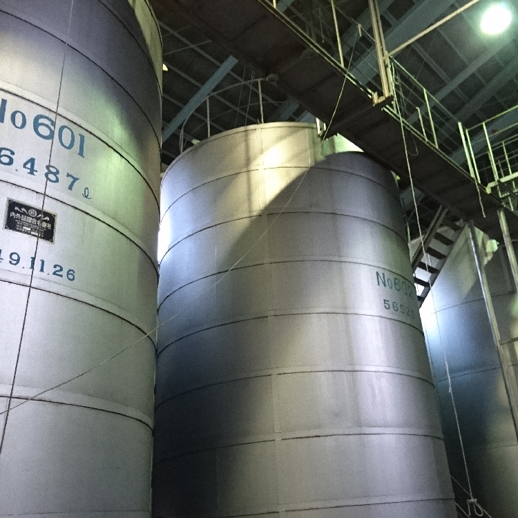 Large stainless steel fermentation tanks inside the brewery.