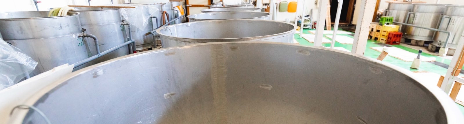 Rows of stainless steel fermentation tanks inside the brewery.