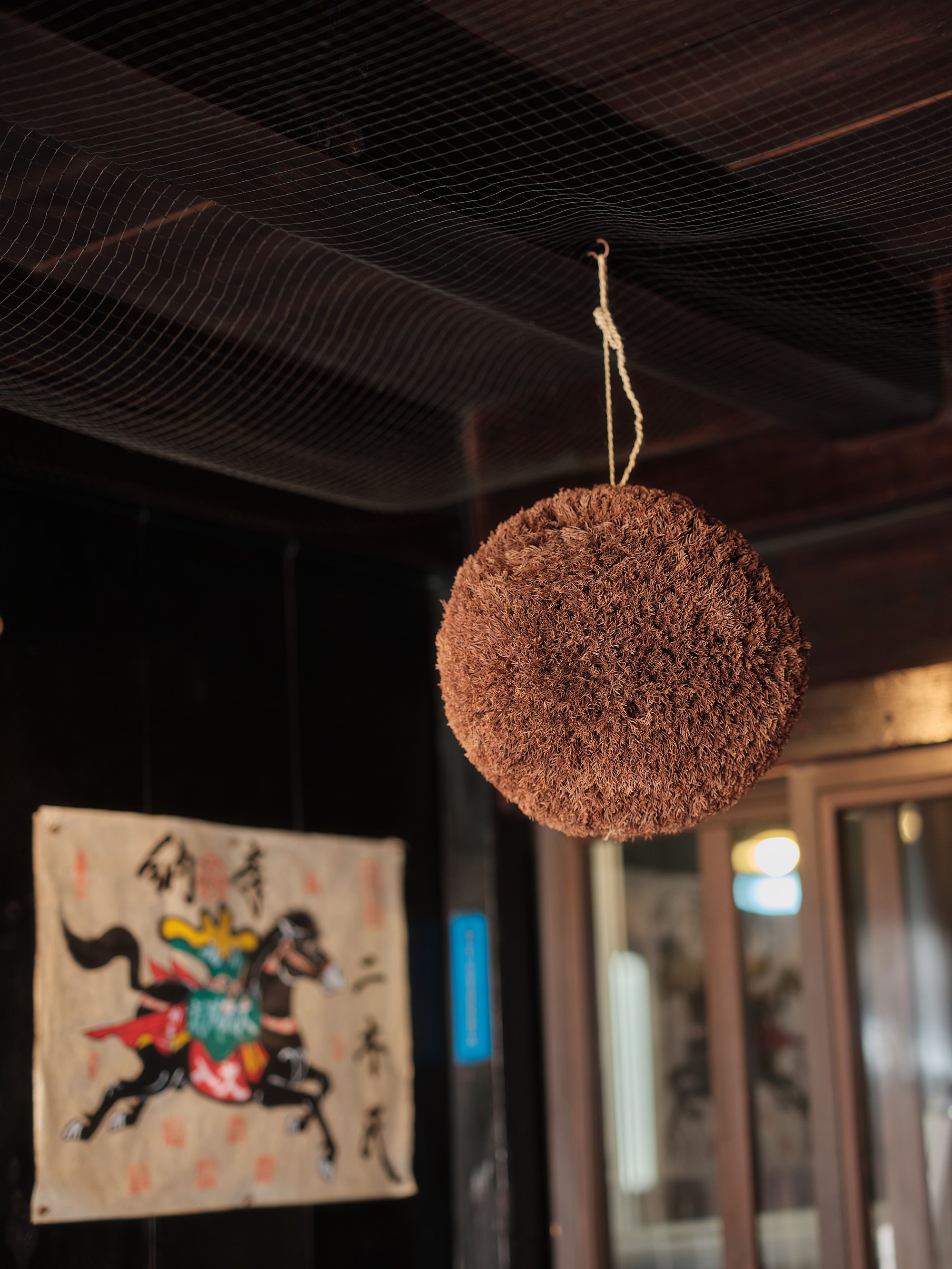A cedar ball (sugidama) hanging beneath the eaves of the brewery entrance, the traditional sign that new sake has been brewed.