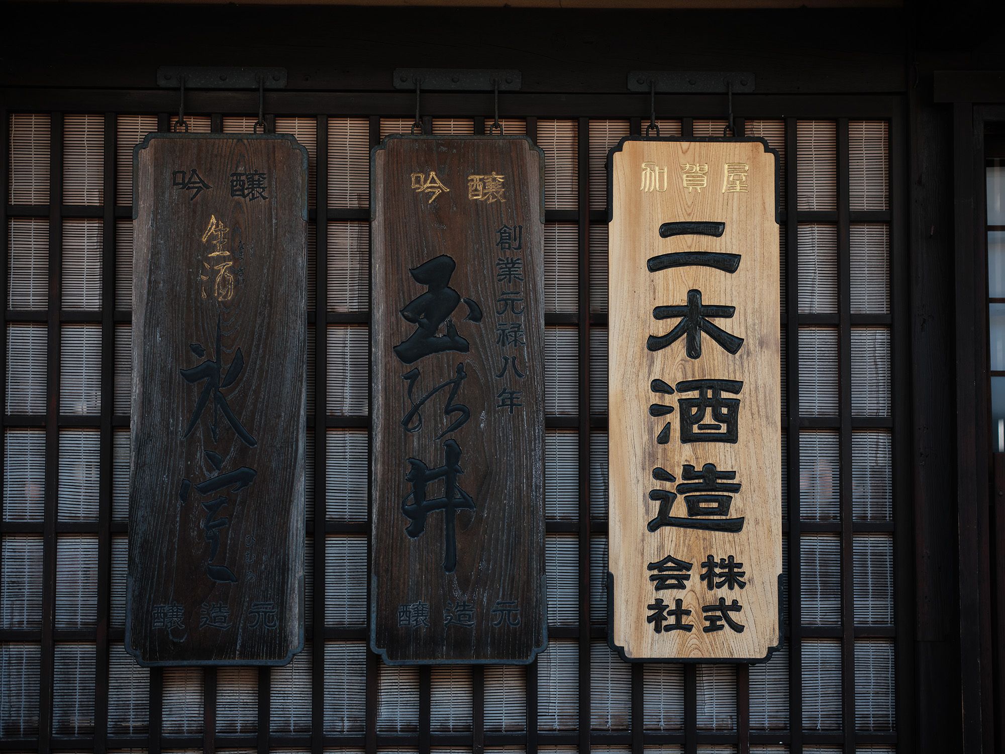 Wooden nameplates at the brewery entrance reading Niki Shuzo, Tamanoi and Himuro, noting the Genroku 8 founding.