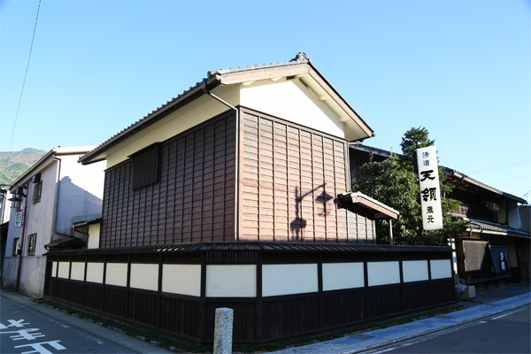 Exterior view of the traditional white-walled kura storehouse building with a 'Tenryo Brewery' sign.