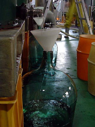 Sake dripping into glass demijohns (tobin-dori pressing)