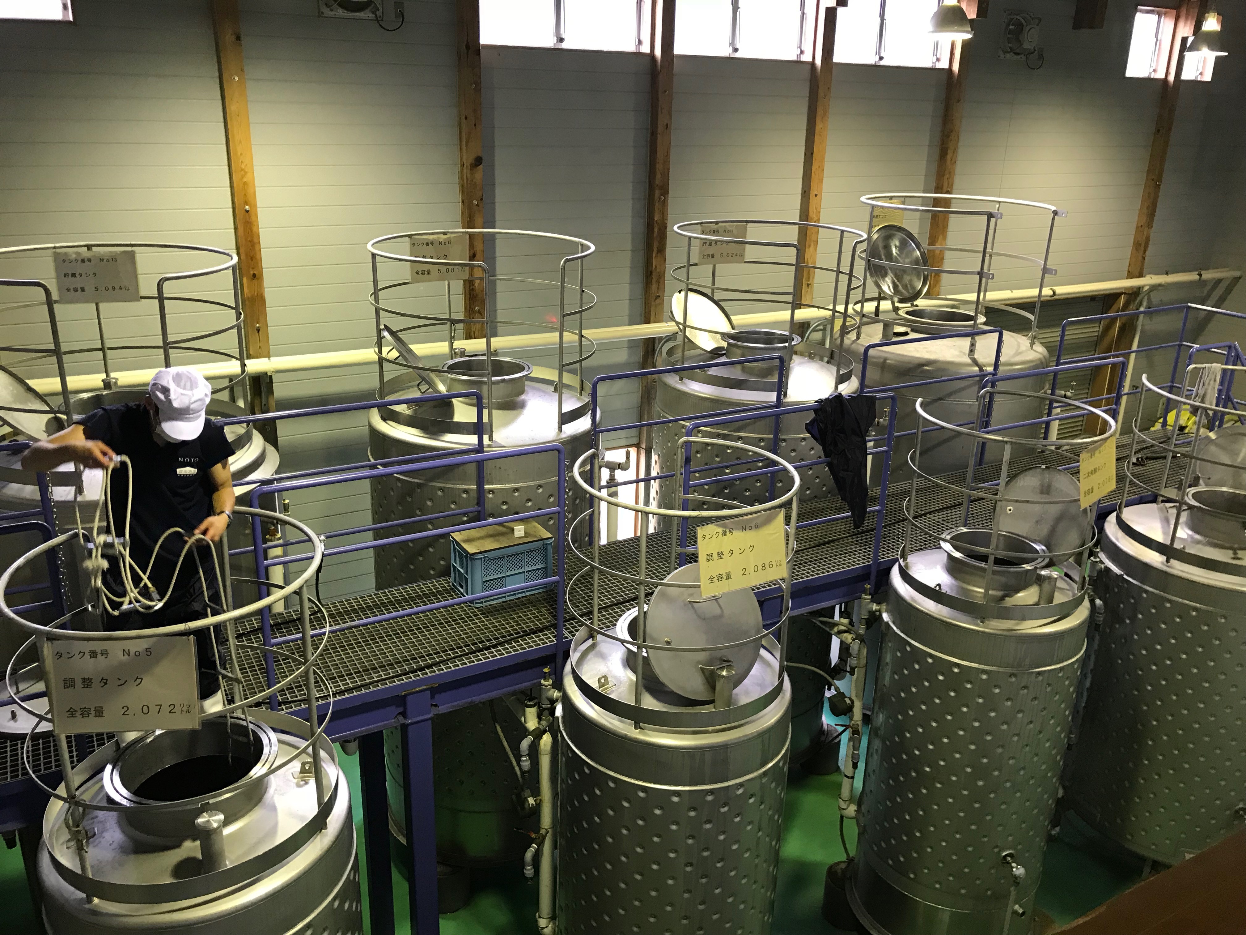 Interior of the liqueur storage building, showing rows of stainless steel tanks used for plum and tea liqueurs.