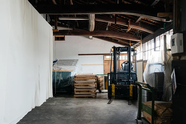 Interior of the brewery's storage warehouse with a forklift and stacked crates.