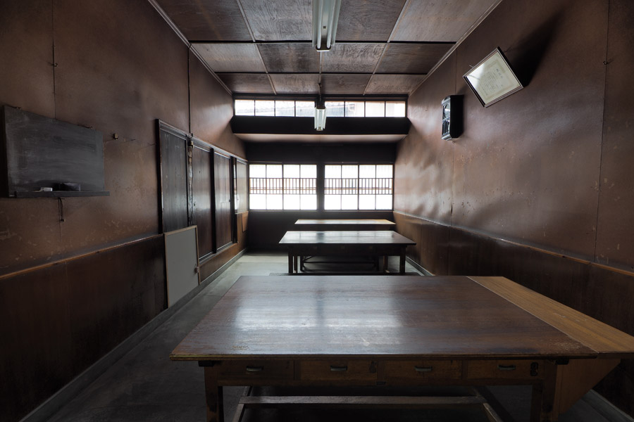 A wood-paneled tasting or meeting room inside the brewery with long tables.
