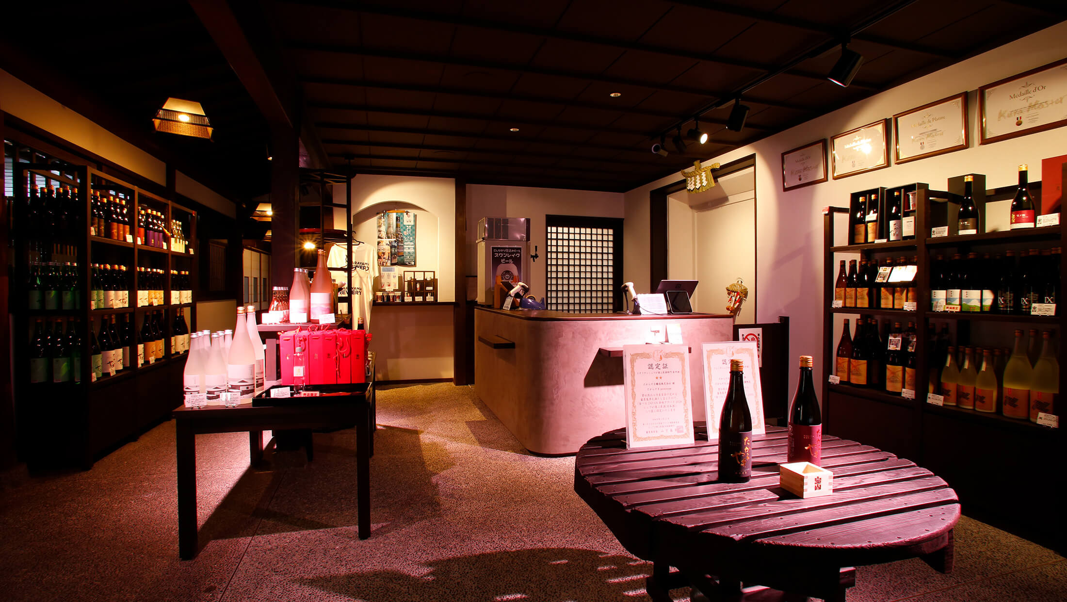 Interior of the brewery's direct-sale shop, with shelves of bottled sake and award certificates on display.