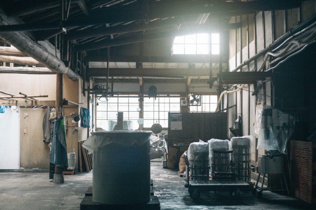 Inside Sasaiwai Shuzo's production building, with steaming and staging equipment for rice preparation.