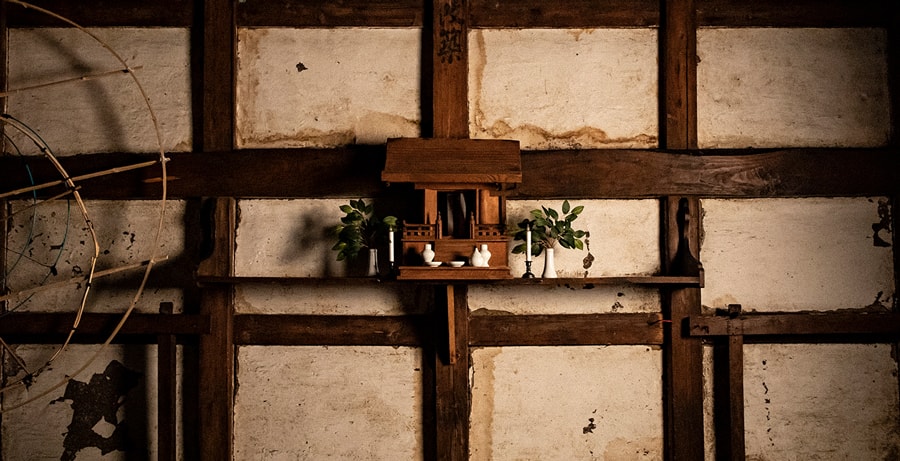 A small household shrine (kamidana) built into the wooden wall inside the brewery