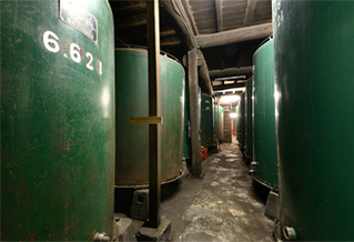 Rows of large fermentation tanks inside the Toukun Shuzo brewery