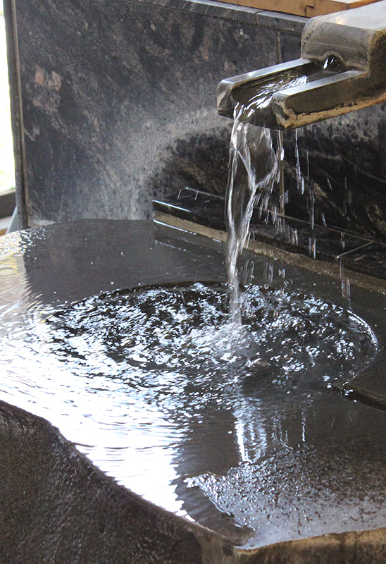 Brewing water flowing from stone spout