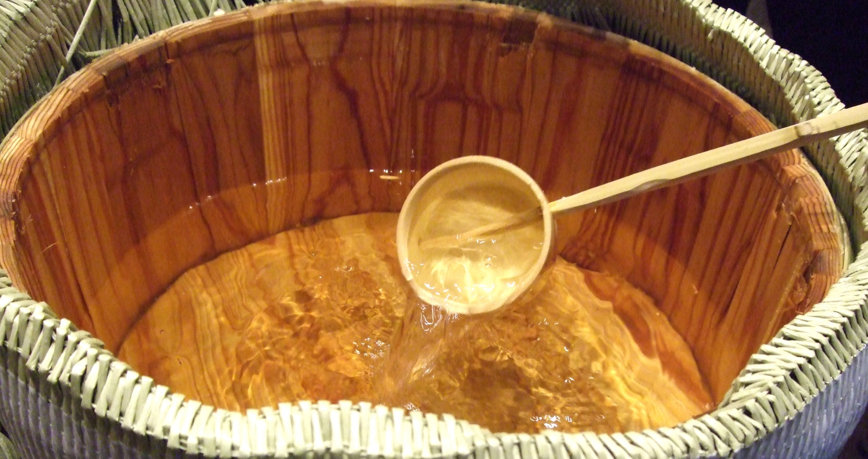 Ladling moromi (fermenting mash) by hand