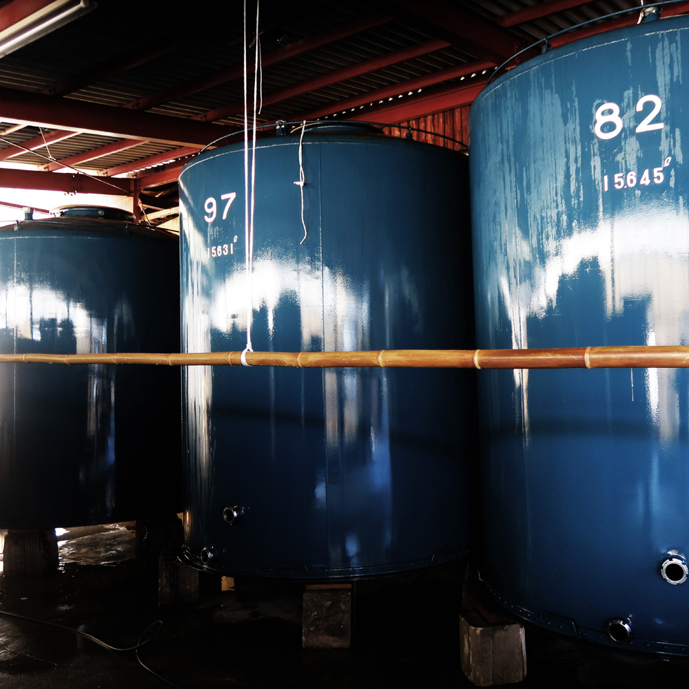 Large blue fermentation storage tanks inside the brewery