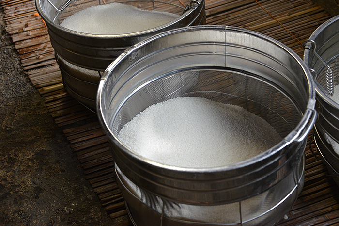 Rice being measured in sieve baskets before brewing