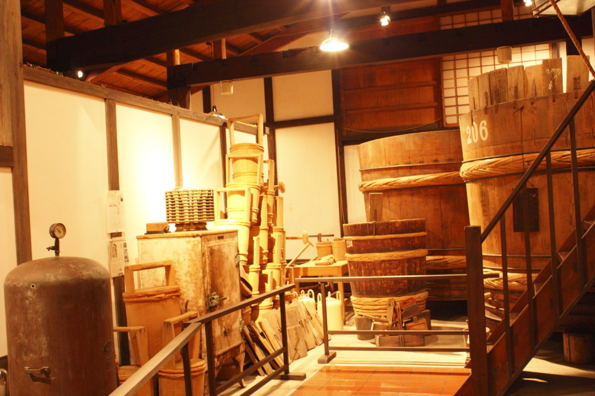 Wooden fermentation tubs and brewing tools displayed inside the museum's former brewing hall.