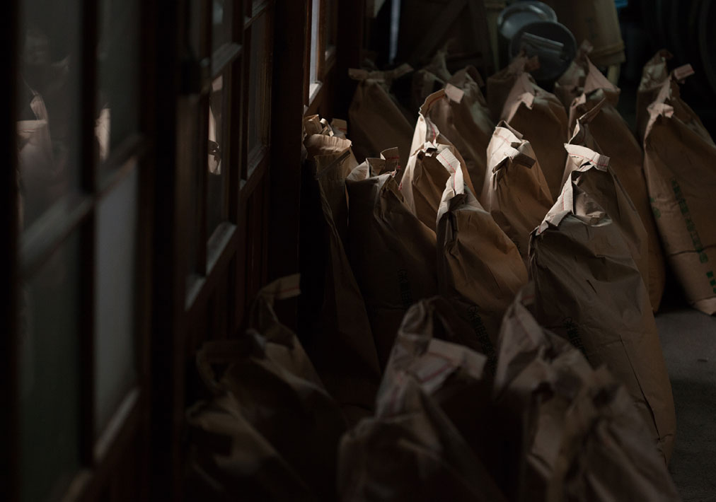 Sacks of rice waiting to be washed inside the brewery.