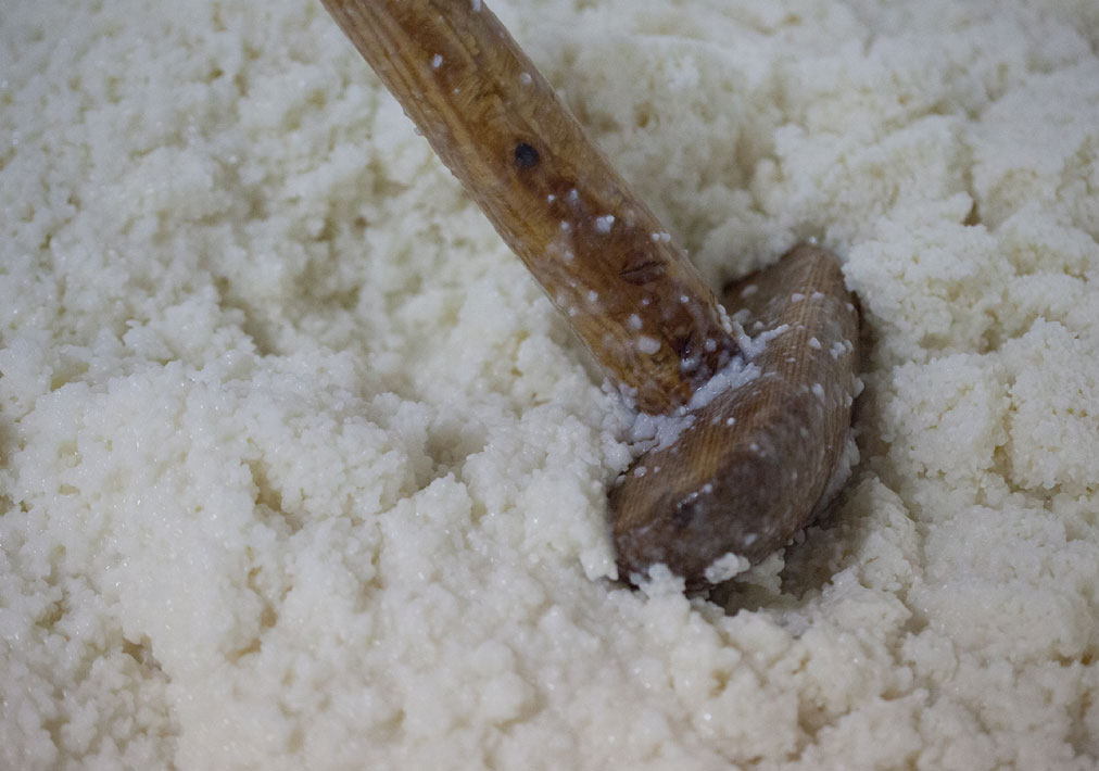 Close-up of moromi mash being worked with a wooden paddle.