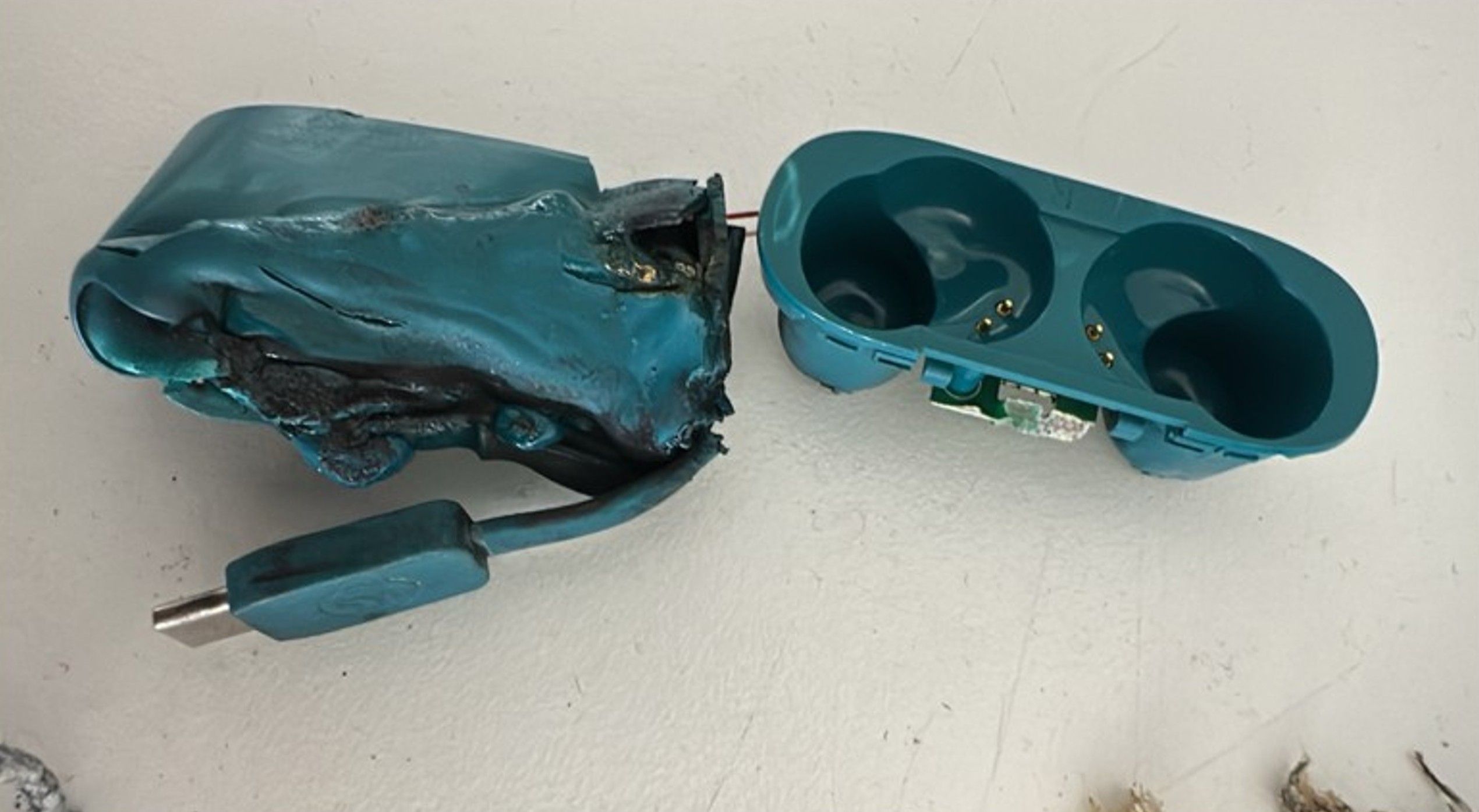 Melted, crushed blue headphone charging case from the LX16 flight incident.