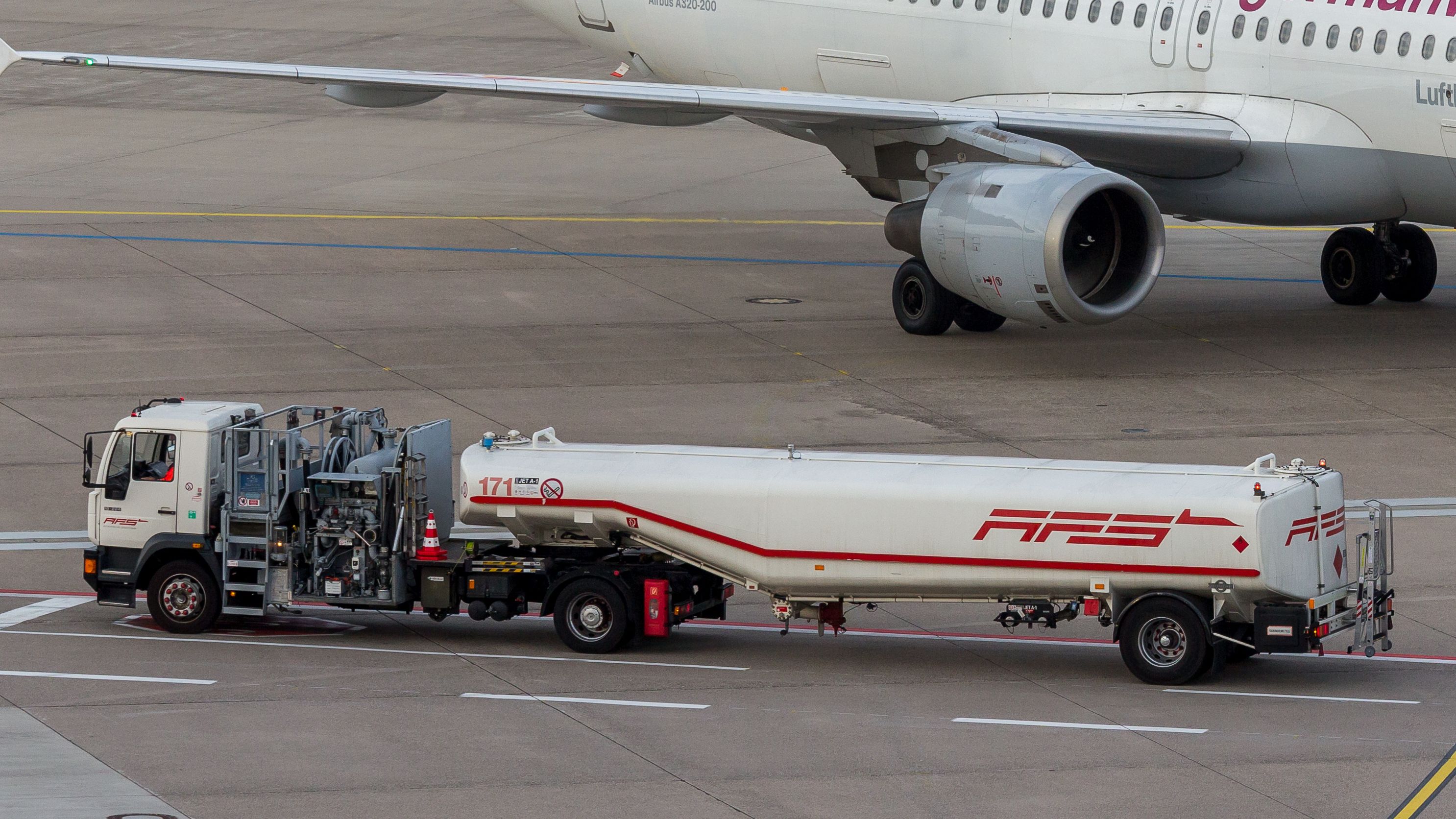 AFS fuel truck refuels a Lufthansa A320 at an airport.