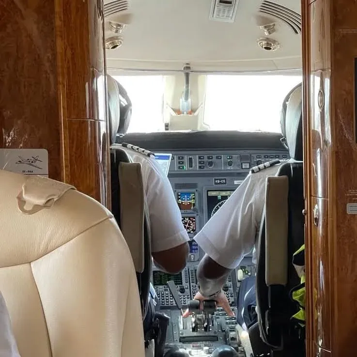View from a private jet cabin into the cockpit with two pilots