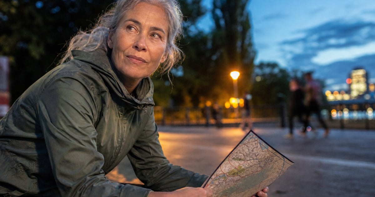 Due runner si fermano davanti a una mappa, concentrati sull’orientamento nel bosco