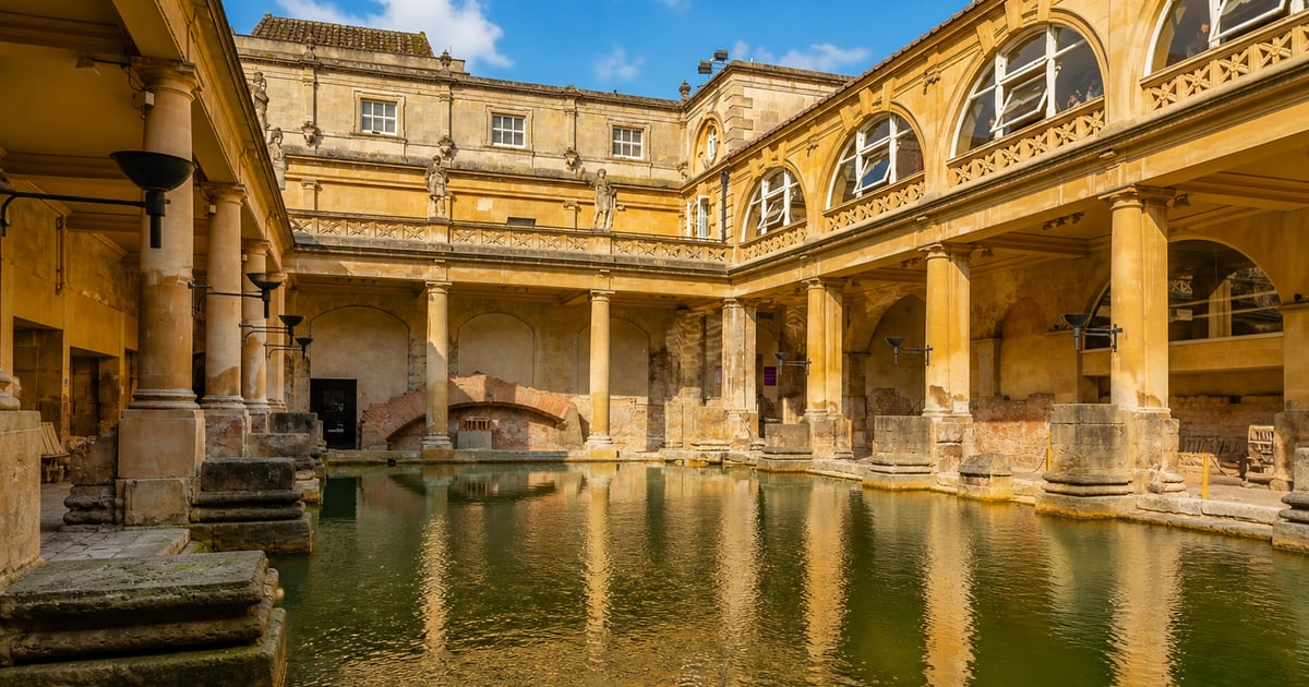 Colonnades antiques baignées de soleil, voyageurs contemplant un paysage méditerranéen